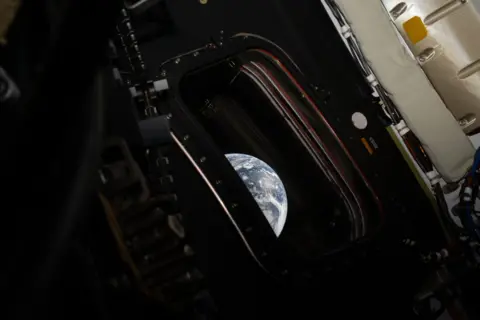 Nasa/Reid Wiseman An image from inside of the Orion capsule, which shows a small window and part of the Earth outside